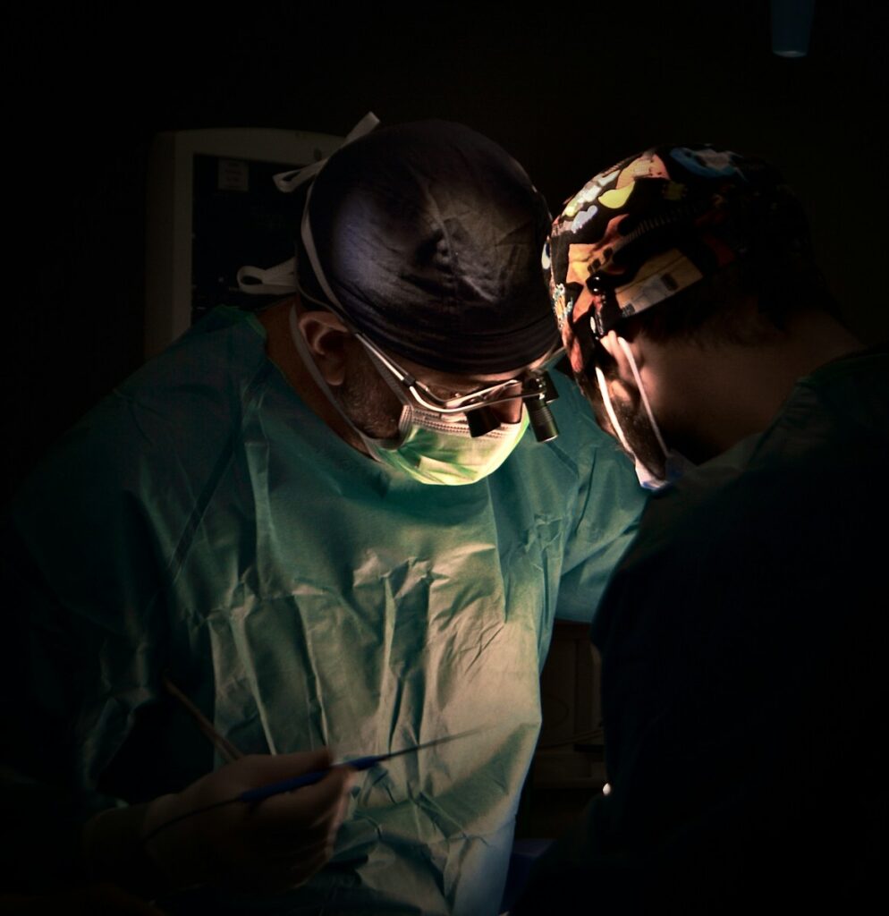 Surgeons performing a medical operation in a dark room.